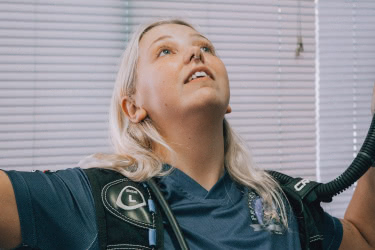 Scuba instructor demonstrating buoyancy control techniques during a classroom briefing