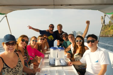 Group of happy divers relaxing and socialising on a dive boat after a trip in Phi Phi, Thailand