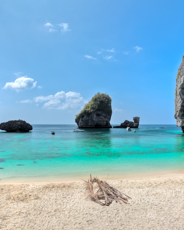 Tropical beach with turquoise water and limestone islands off the coast of Phi Phi, Thailand