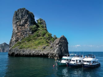 Island Divers dive boats moored near the Koh Bida islands, featuring dramatic limestone cliffs in Phi Phi, Thailand