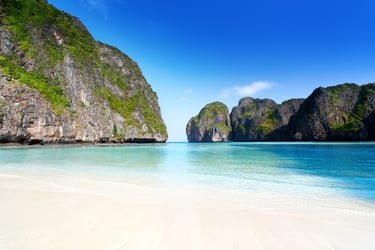 White sand beach and turquoise water framed by limestone cliffs at Maya Bay on Phi Phi Leh Island, Thailand